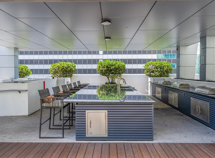 A modern outdoor kitchen with a wooden floor and a bar area.